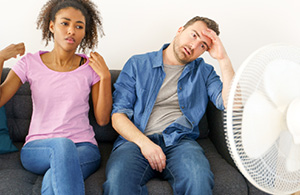 Couple on couch with broken air conditioner